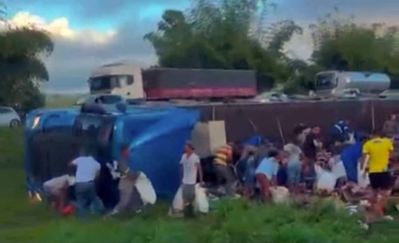 Caminhão sai da pista, tomba e carga de cerveja é saqueada na BR-324, na região de Feira de Santana